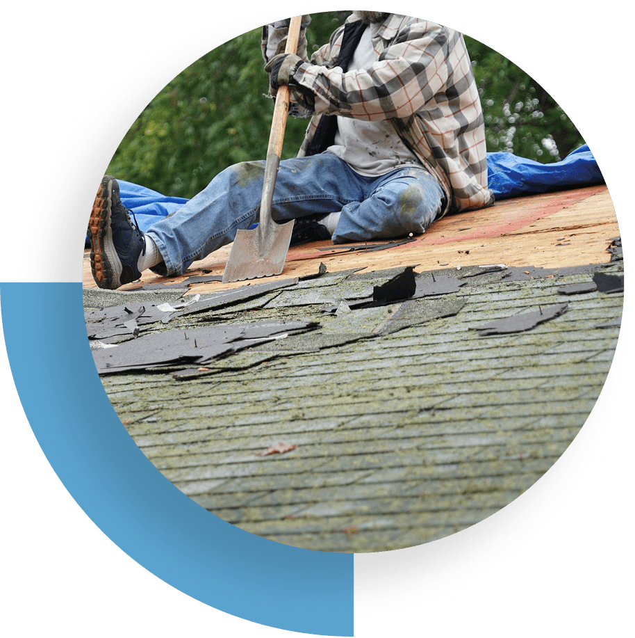 A worker repairing a shingled roof using tools.